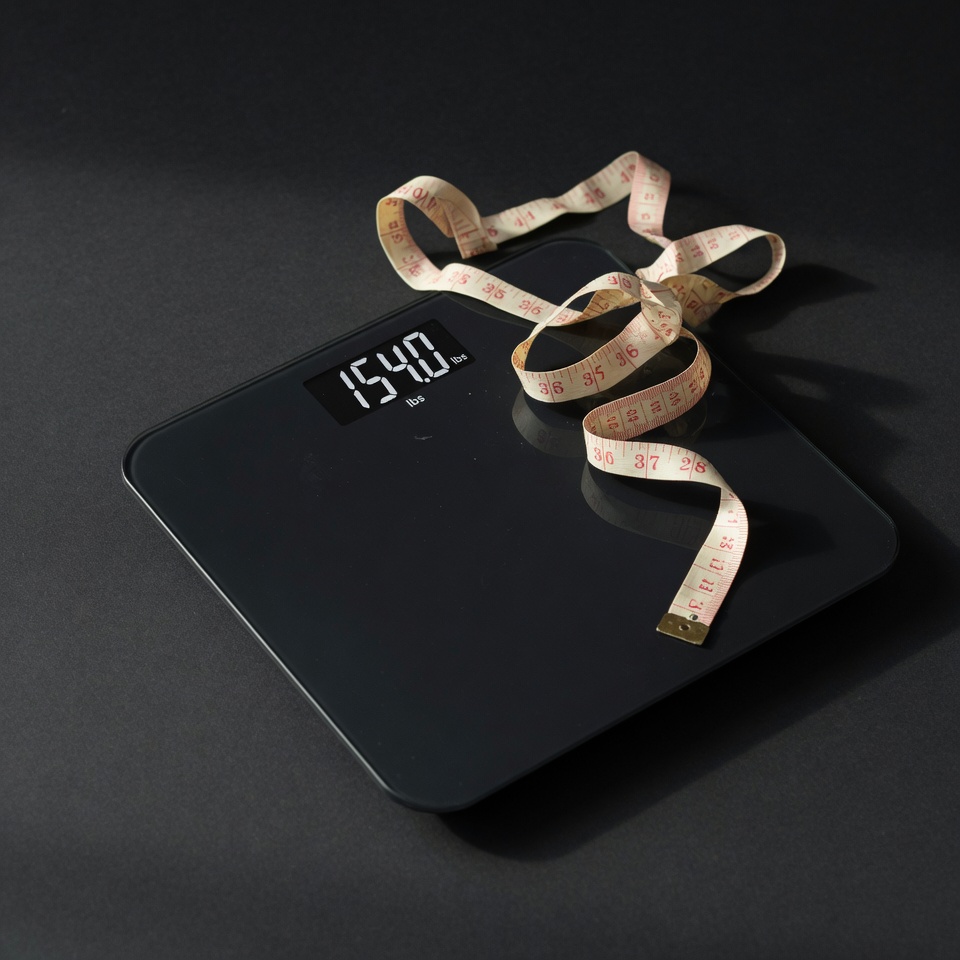 Measuring tape draped over a bathroom scale